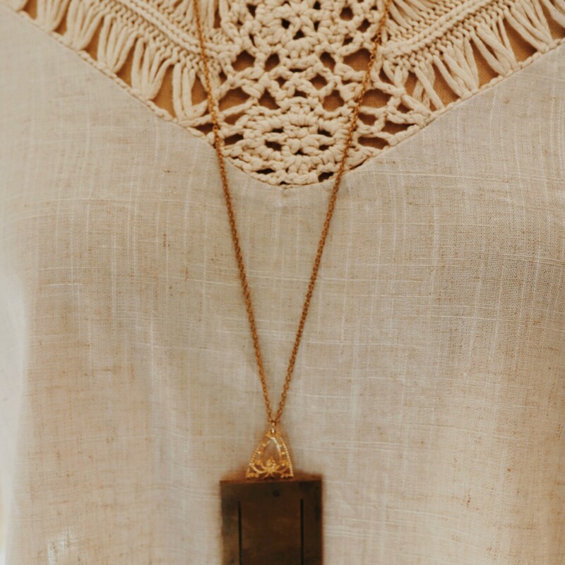 This unique necklace has a U engraved brass plate. It hangs from a 32 inch chain.