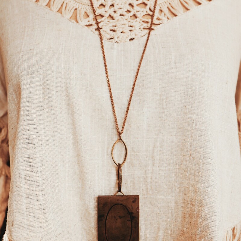 This unique necklace has a Q engraved brass plate. It hangs on a 32 inch chain.