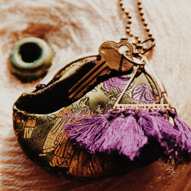 - handmade necklace featuring a coin purse, key and purple fringe.
- 17 inch brass chain