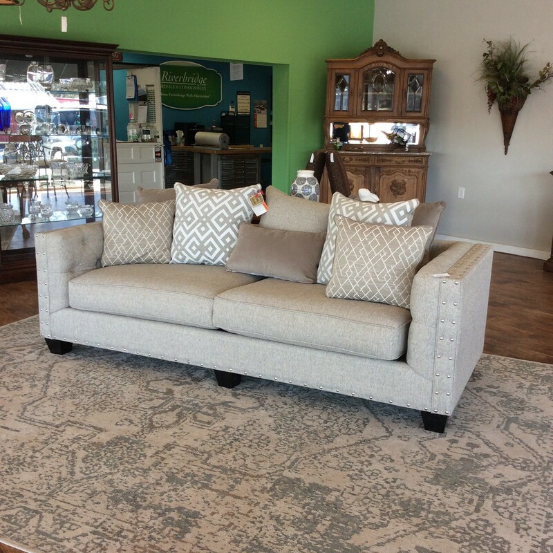 This is a gorgeous sofa from Cindy Ctawford Home! Upholstered in beige with a big, bold nailhead trim. Eight pillows included.