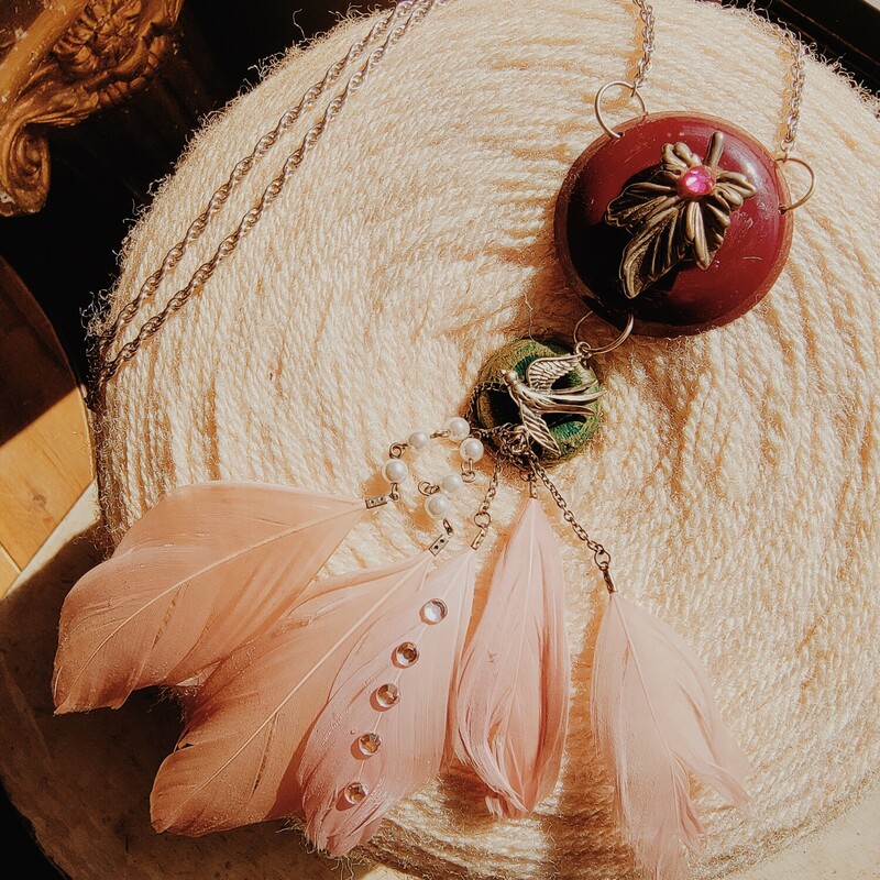 - Hand crafted necklace<br />
- 30 Inch chain<br />
- Brass leaf with pink rhinestone center<br />
- Silver bird charm<br />
- 6 inches of pink feathers