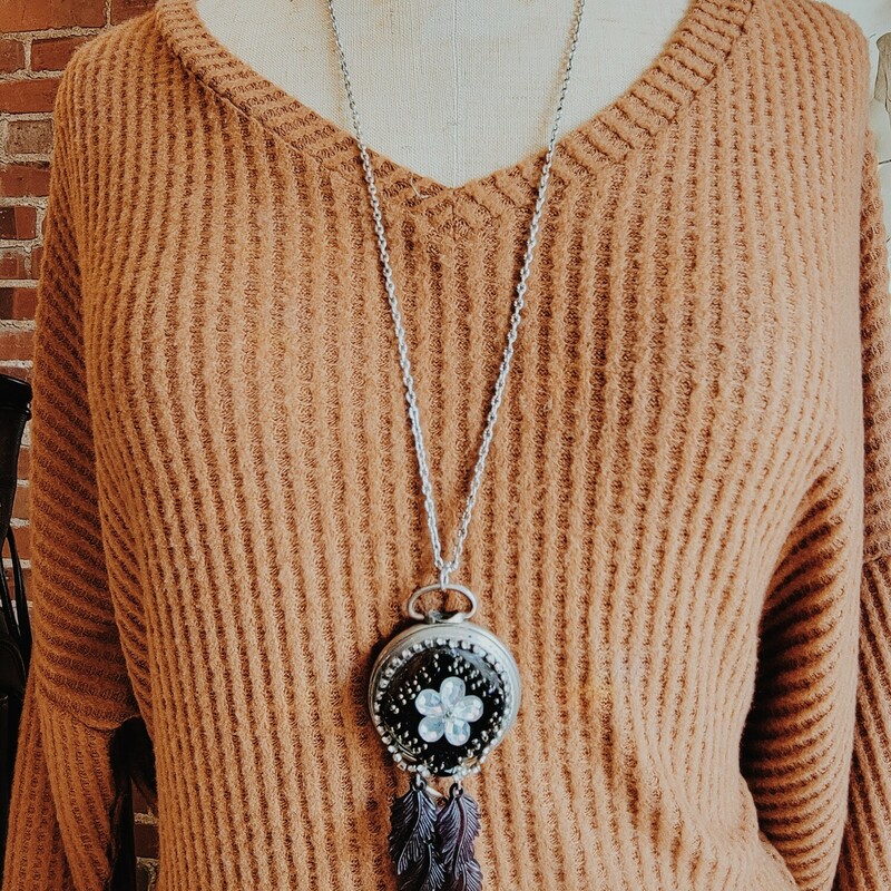 - Hand crafted necklace
- 32 Inch chain
- Pocket watch pendant with flower center
- Black plastic feathers