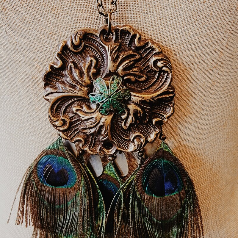 This beautiful necklace was hand crafted! The artist used a vintage floral medallion for the pendant and attached faux peacock feathers.
Chain: 32 Inches