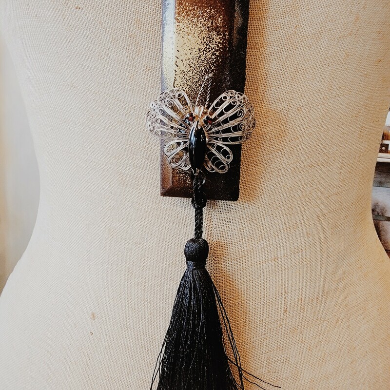 This one of a kind necklace was hand crafted! The artist used an old metal piece for the pendant and attached an antique butterfly charm to the front. A 4 inch black tassel hangs from the pendant.
Chain: 31 Inches