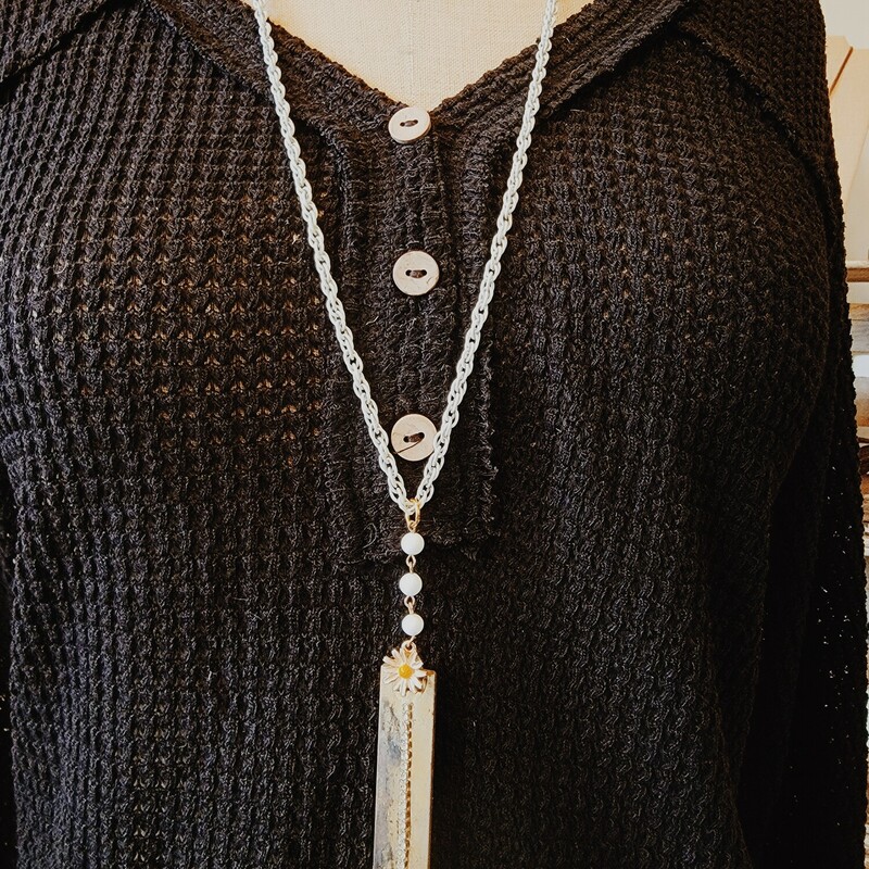 This unique necklace was hand crafted! It is on a 32 inch white chain with gold accents. The pendant is a brass plate with a rhinestone I on it and a flower above it!
