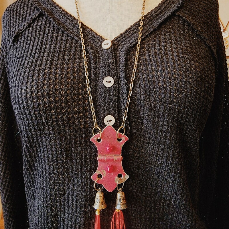This necklace was hand crafted! The artist used a red hinge for the pendant and hung two brass bells with red tassels from it.
Chain: 30 Inches