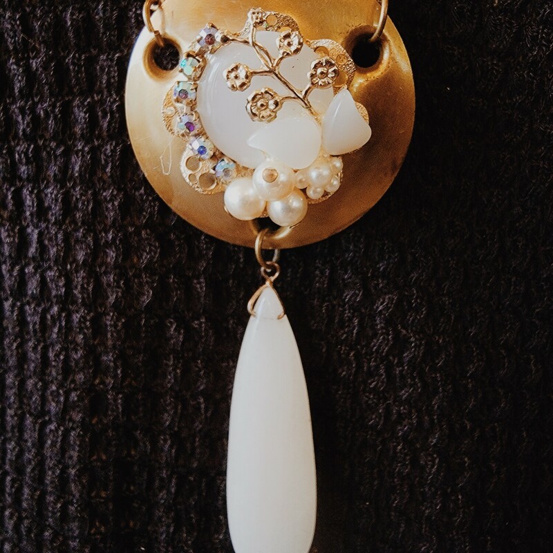This elegant necklace was hand crafted!  It has a vintage door lock piece as its pendant with a collage of faux pearls on the center and a stone hanging from it.
Chain: 32 Inches