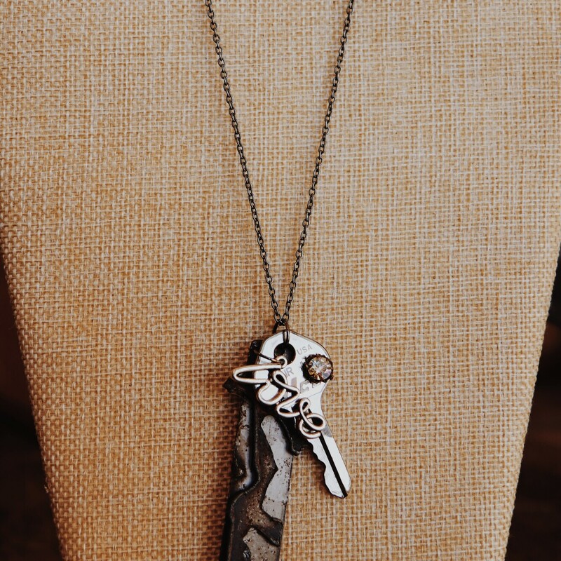 This necklace from Kelli Hawk Designs was handmade from vintage pieces! The centerpiece features three metal pieces, one of which is an old key with a rhinestone attached, and another that says love. This hangs on a 19 inch chain.