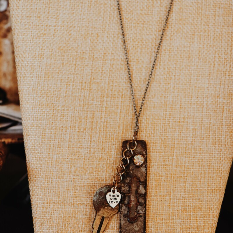 This necklace from Kelli Hawk Designs was handmade from vintage pieces! The centerpiece features two vintage metal pieces, one of which is an old key with a made with love tag attached. This hangs on a 20 inch chain.