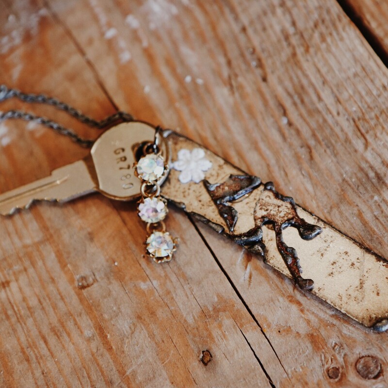 This necklace from Kelli Hawk Designs was handmade from vintage pieces! The centerpiece features two vintage metal pieces, one of which is an old key with three rhinestones attached. This hangs on a 20 inch chain.