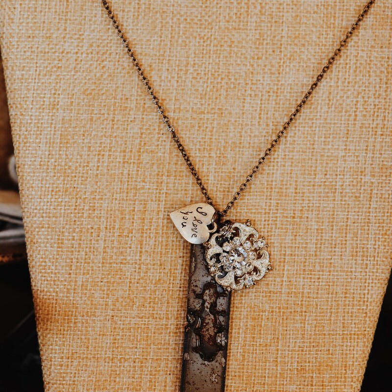 This necklace from Kelli Hawk Designs was handmade from vintage pieces! The centerpiece features a vintage metal pieces, a rhinestone pendant, and an I love you heart. This hangs on a 22 inch chain.