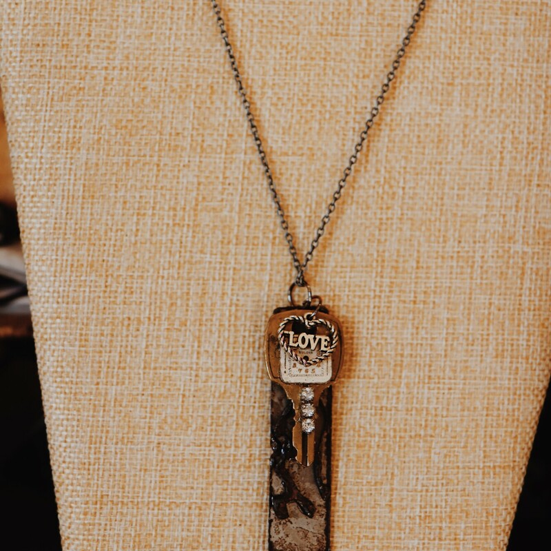 This necklace from Kelli Hawk Designs was handmade from vintage pieces! The centerpiece features two vintage metal pieces, one of which is an old key with a watch face attached. It also has a heart charm that reads LOVE and hangs on a 19 inch chain.