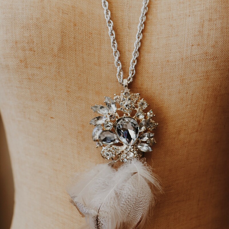 This elegant necklace is on a 30 inch chain and has a beautiful rhinestone pendant with feathers hanging from it!