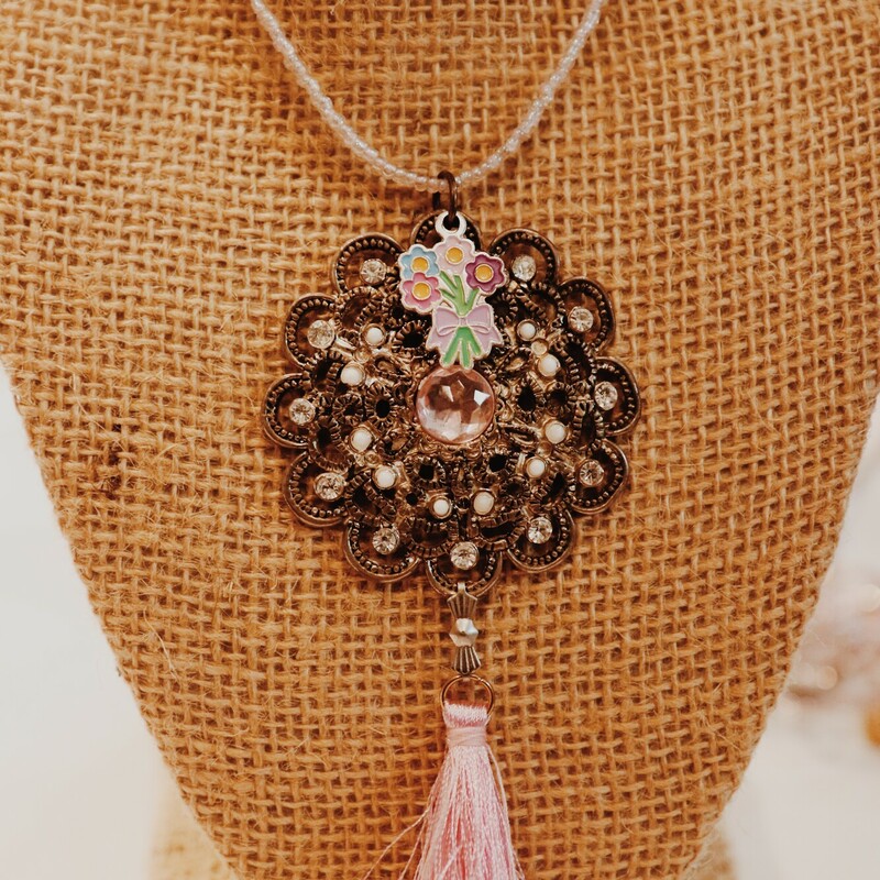 This lovely Kelli Hawk Designs necklace has a vintage broach made to be the pendant with a flower bouquet charm and a pink tassel. It hangs on a 15 inch strand of beads with a 3 inch extender.
