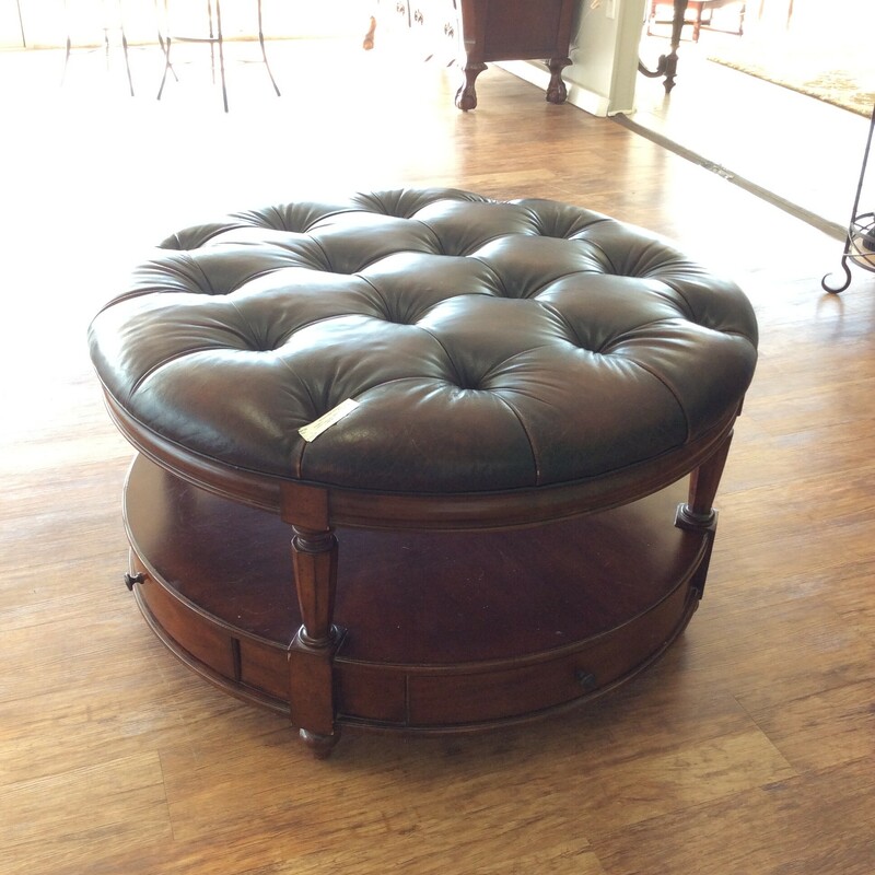 A very pretty coffee table that is very funtional and  can also be used as an ottoman. The top is leather and it is button tufted. It also has four drawers and a bottom shelf.
Measures 42x22