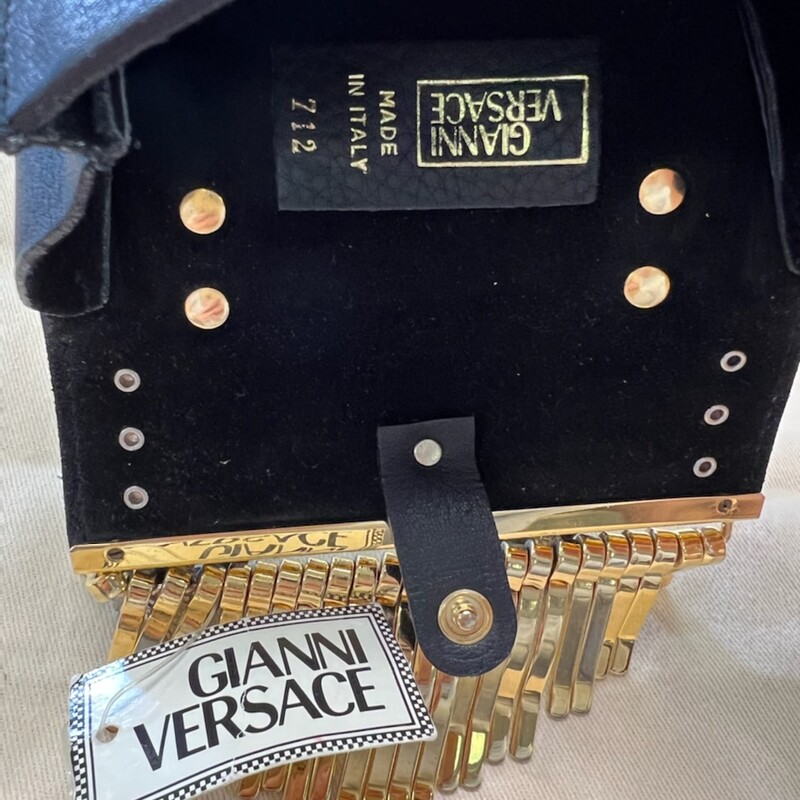 GIANNI VERSACE - VINTAGE<br />
Absolutely fantastic, authentic, unused Gianni VERSACE belt bag made from pebbled soft black leather with huge gold fringe, small Medusa head button and silver tone western buckles. Rad, rare and pure decadence. GIANNI PACKS MY POUCH. LABEL: GIANNI VERSACE, MADE IN ITALY. SIZE: SMALL. MEASUREMENTS: WIDTH: 4.75\" HEIGHT: 3\" DEPTH: 1\" EMPTY DROP: 2\" FABRIC CONTENT: NO LABEL. LEATHER AND GOLDTONE/SILVERTONE HARDWARE. CONDITION: MINT, DEADSTOCK. TAG ATTACHED.<br />
\"TRADESY\" has this for sale for $840.00