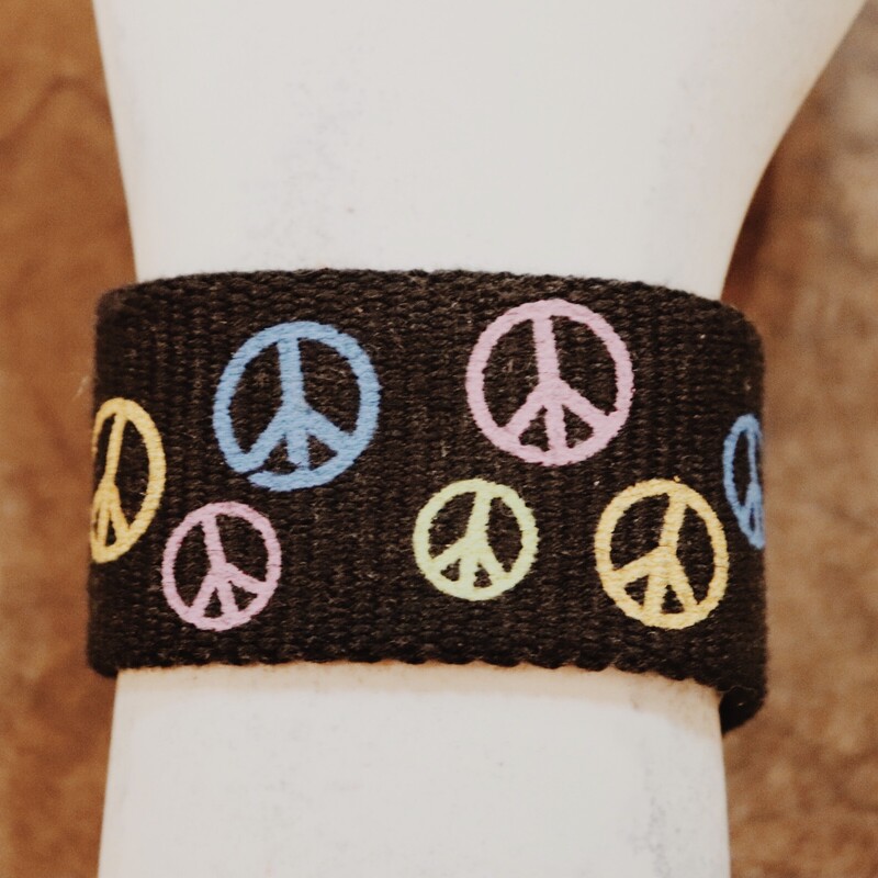 Black 2 inch wide cuff bracelet with colorful peace signs all over. It is 8 inches long and snaps in the back. Very boho and retro.