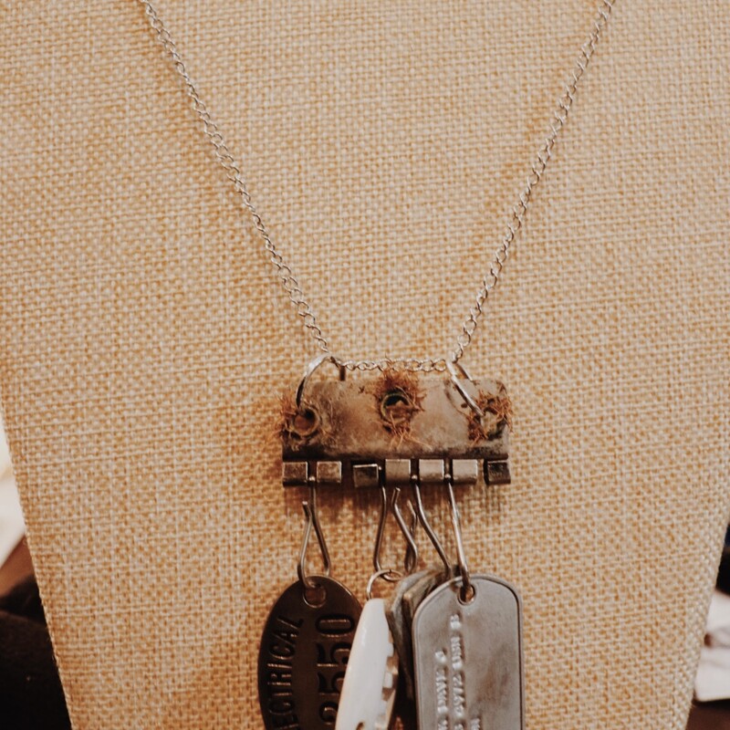 This one of a kind, handmade necklace is on a 32 inch chain and has an assortment of pendants including dog tags and keys!