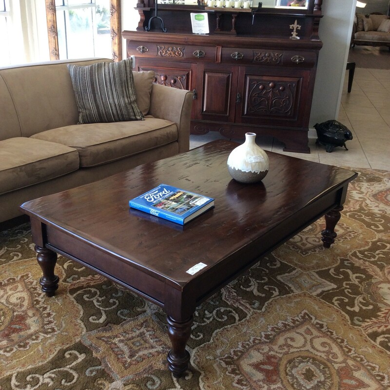 Very large coffee table with a distressed rustic look top.
It has two large drawers with cup hardware. It is a very dark brown or black.
Measures 58x36