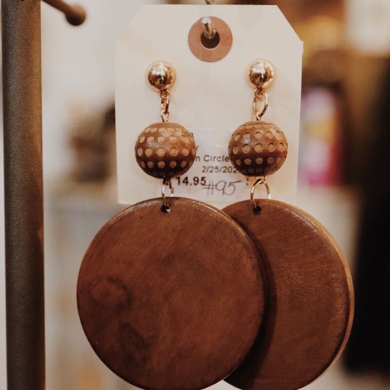 These earrings are made from wood. The post is gold and attached with a small wooden ball that looks like it has polka dots on it, and the largest wooden circle is attached at the end. These are medium weight. 4 long.