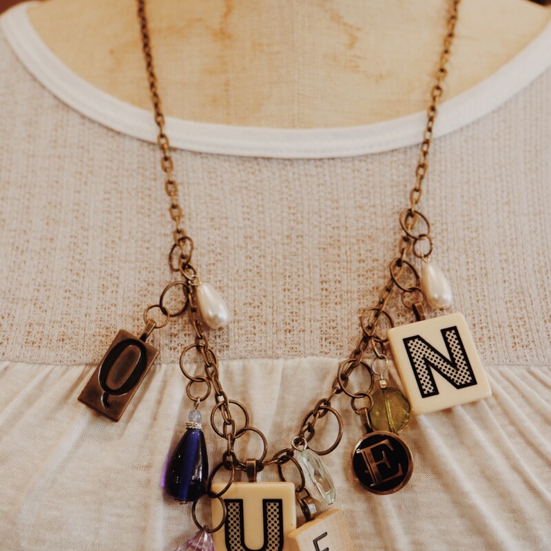 This handmade necklace spells out queen in game pieces and is on a 26 inch chain!