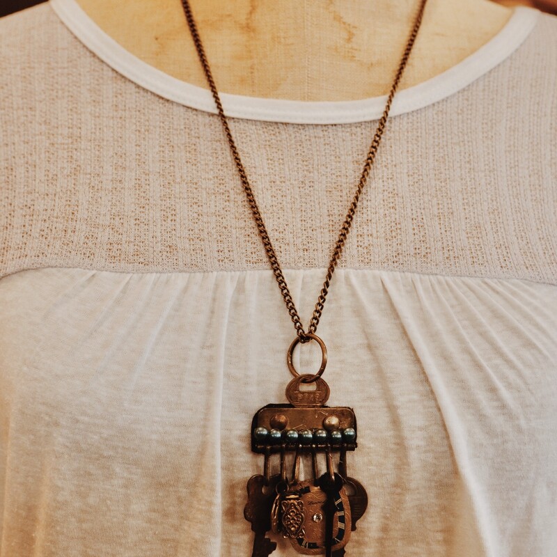 This one of a kind, handmade necklace has an assortment of vintage trinkets as the pendant and is on a 26 inch chain!