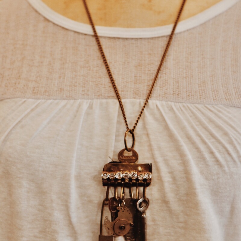 This handmade necklace has an assortment of vintage trinket as the pendant and hangs on a 26 inch chain!