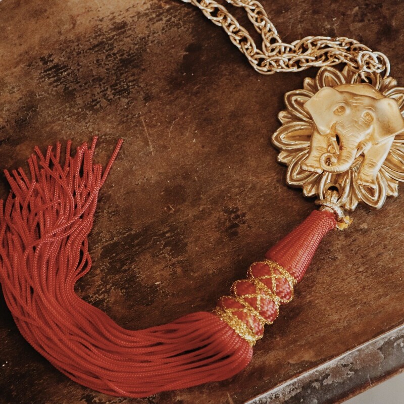 This handmade necklace is on a 30 inch chain and has a 8 inch red tassel!