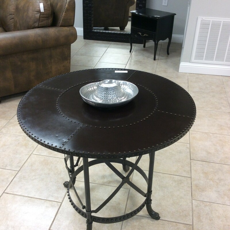 This is a handome round metal table with a nailhead trim.