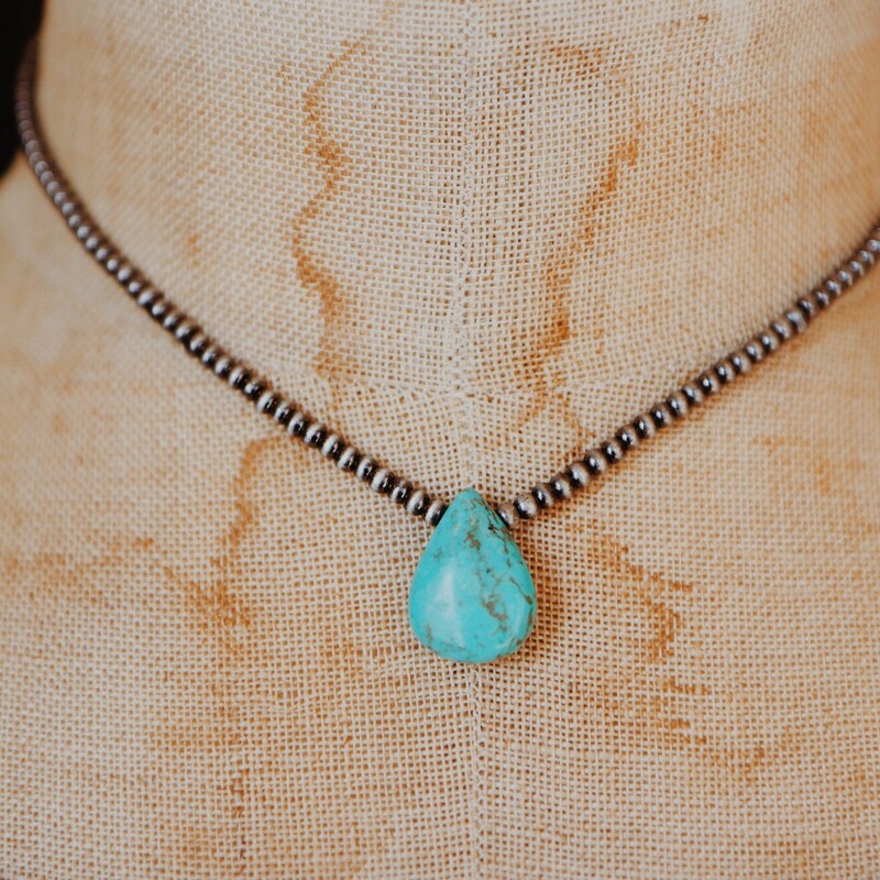 Small metal beaded choker with a tear drop turquoise pendant. The choker measures 6 inches and the pendant is a half inch.