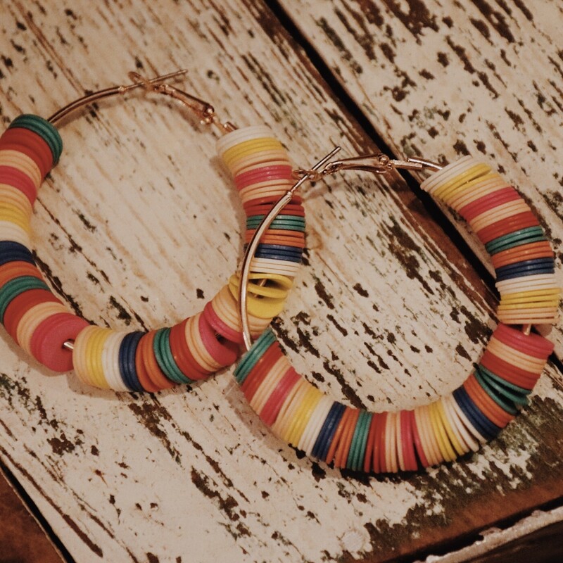 Colorful Hoop Earrings with multicolored plastic discs on the hoops. Measuring 2 inches in diameter.