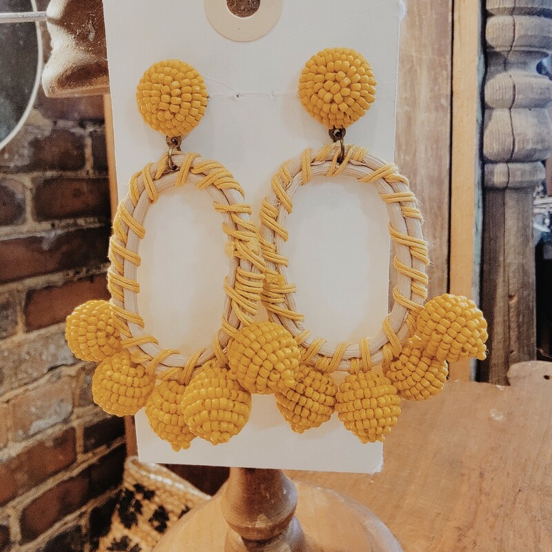 Yellow Dangle earrings made of ball of yellow beads, yellow yarn, and straw ovals. Measuring 3 inches long.