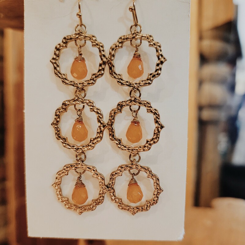 These earrings are gold toned with 3 circles with orange bead in the center of each one. They are light weight. 3 long.