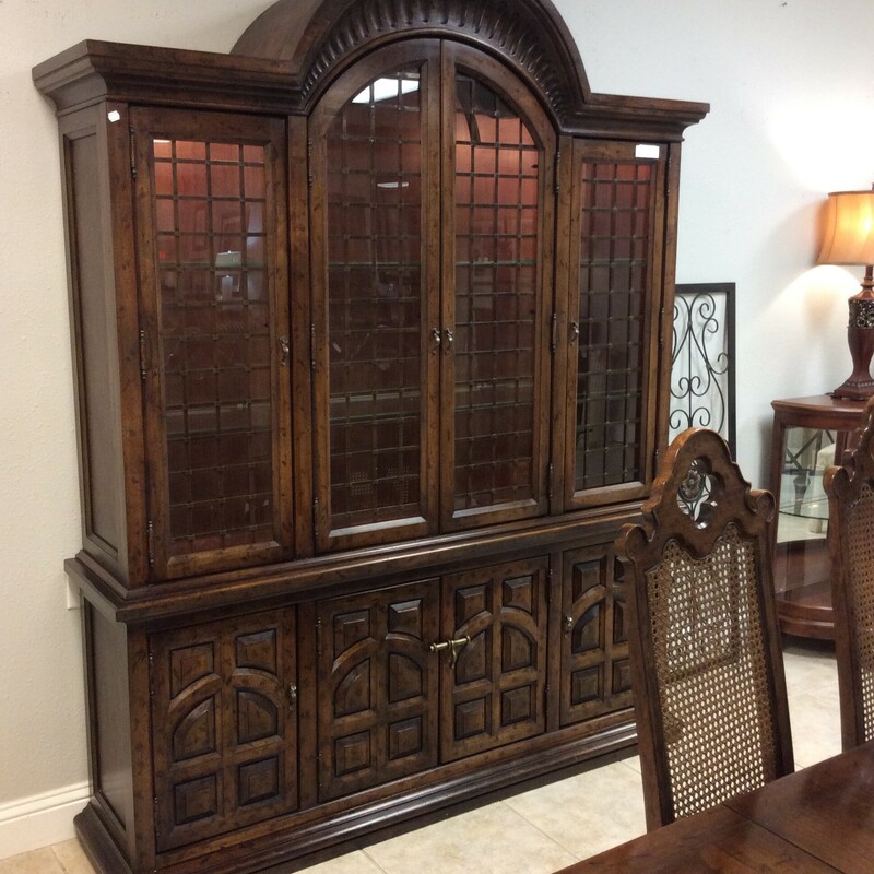 This china cabinet by Drexel is loaded with Old World Charm! It features a dark wood finish, carved details, glass shelving, interior lighting and cabinet space at the bottom.