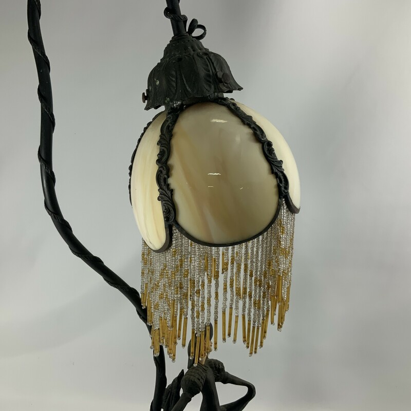Art nouveau table lamp bronze  Depicts a lovely woman in a flowing dress and wide brimmed hat  Amber colored glass shade with beaded fringe
Floral  accents
Good condition needs some attention to get it to work again hat shows a scratch on the brim
21 inches high