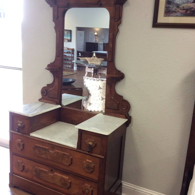 This is a  lovely Victorian mahogony dresser and mirror. The mirror has a pair of carved shelves. The dresser top is marble and has the original hardware.