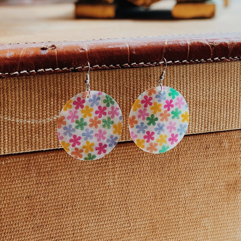 Daisy Shell Earrings Composed of cloudy seashell with printed multi colored daisies covering the shell. Measuring 3 inches long
