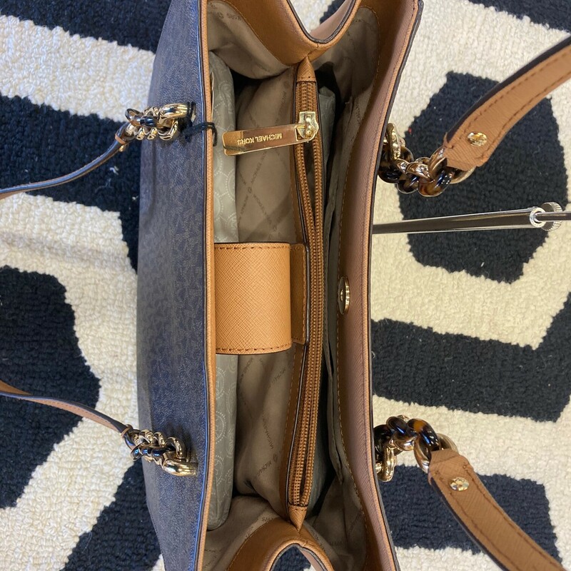 This Michael Kors satchel has logo-print canvas with  100% leather & Gold-tone hardware.<br />
This bag has two inside pockets with a middle zip compartment<br />
Lining: 100% polyester<br />
This bag is in great consition