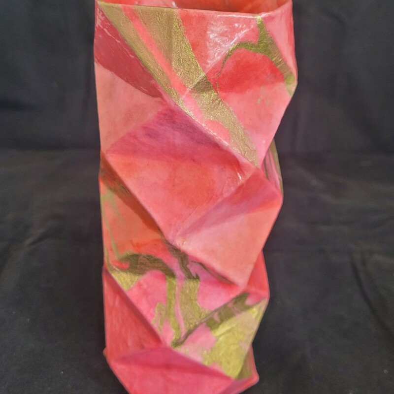 Artist: Rich Gray
Title: Paper Vase
Origami inspired vase.  Constructed of cardstock scored and creased in a diamond pattern then folded into a faceted cylinder and covered with coral and gold colored momigami paper from Thailand.  Glass liner.
3 x 3 x 8