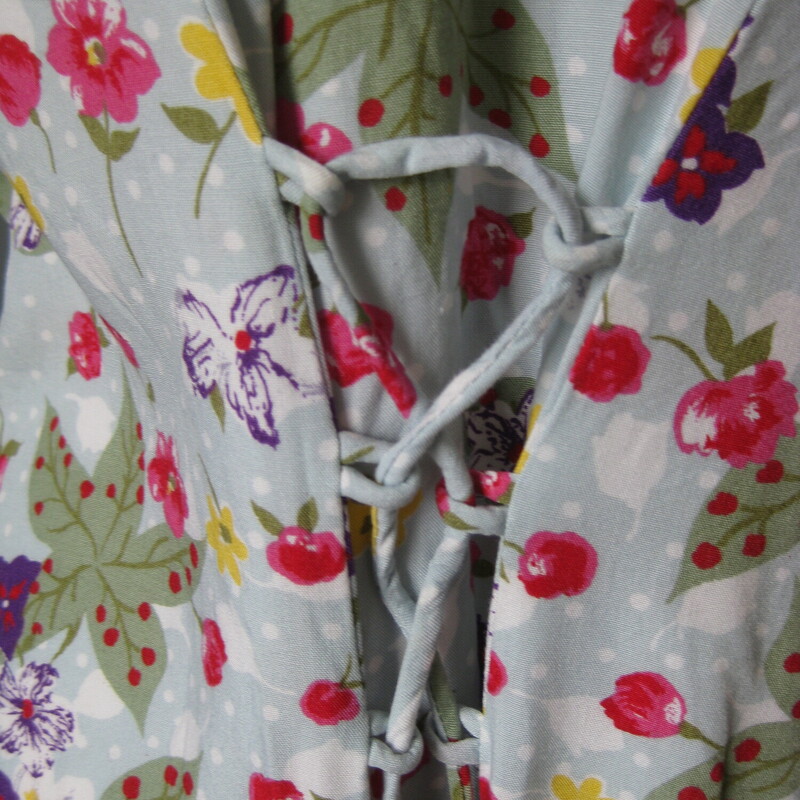 Vtg Jamie Brooke Floral, Blue, Size: 18<br />
Pretty floral rayon dress from the late 80s or early 90s.<br />
Pale aqua background with yellow, purple and red flowers<br />
Long fully buttondown with fabric coverd buttons and loops<br />
Short sleeves<br />
Corset lacing in the back which allows a lot of leeway as to fit.<br />
unlined<br />
LARGE shoulder pads<br />
100% rayon<br />
<br />
by Jamie Brooks<br />
marked size 18,  but please use these flat measurements:<br />
Shoulder to shoulder: 17.5<br />
armpit to armpit: 22.5<br />
waist: up to 21.75<br />
hip: 28 1/2<br />
length: 33<br />
<br />
excellent condition, except two of the buttons have lost their fabric coverings and one is a little cracked, also a little bit of fraying at the back of the neckline<br />
<br />
thanks for looking!<br />
#44286