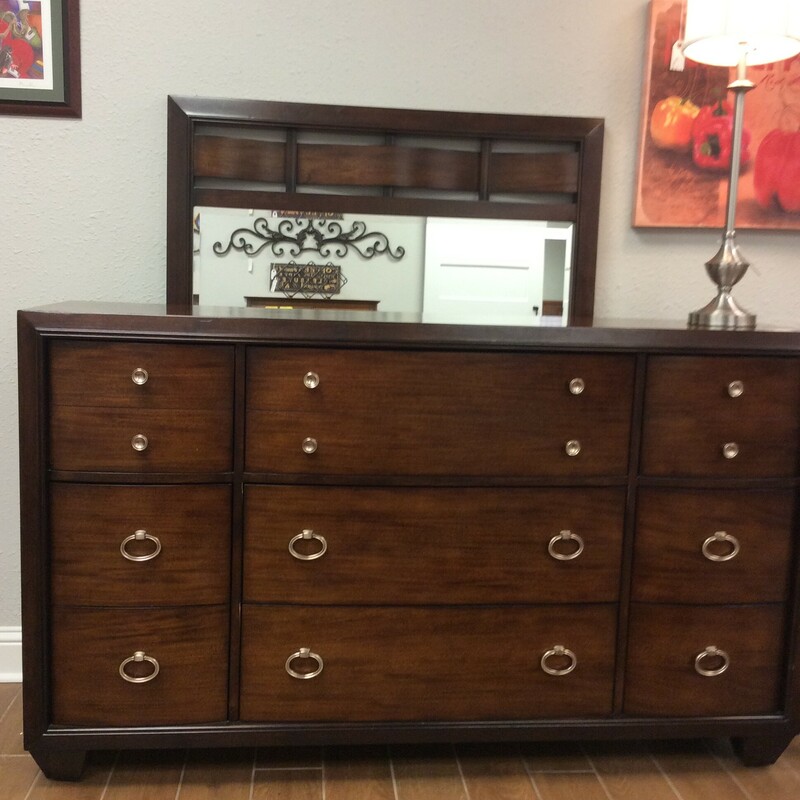 This dresser by Lane Furniture is contemporary in style and features a dark wood finish. It includes 9 drawers with dovetail jointing and an attachable mirror.
