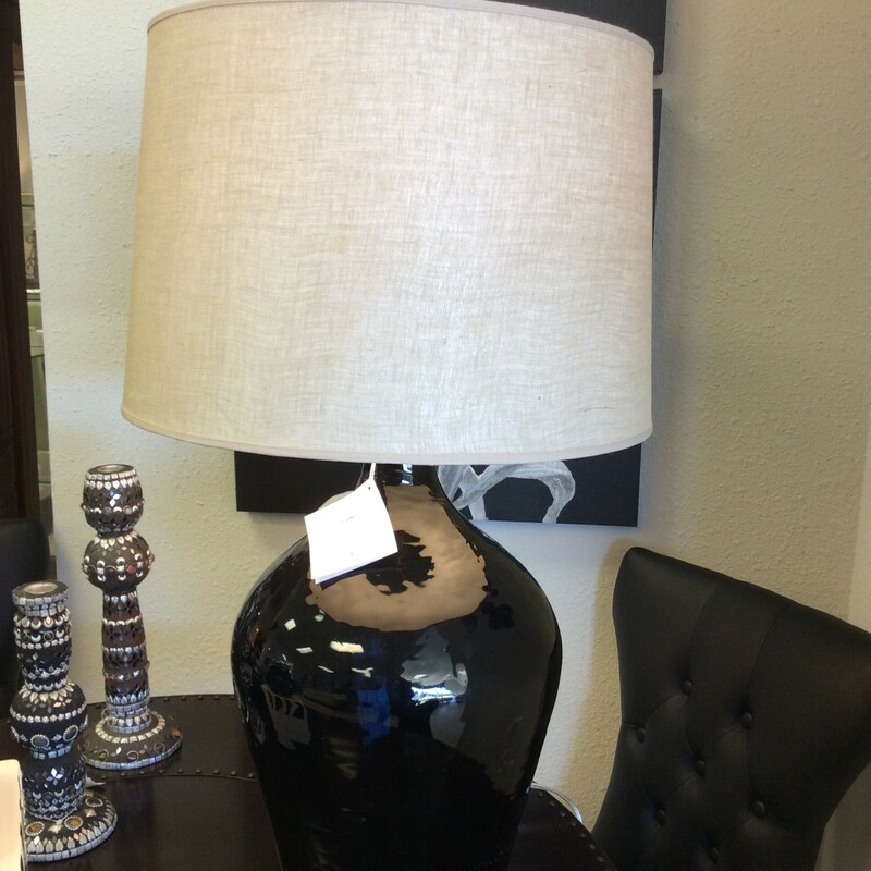 This handcrafted design by Uttermost features a large black base and a beige shade.