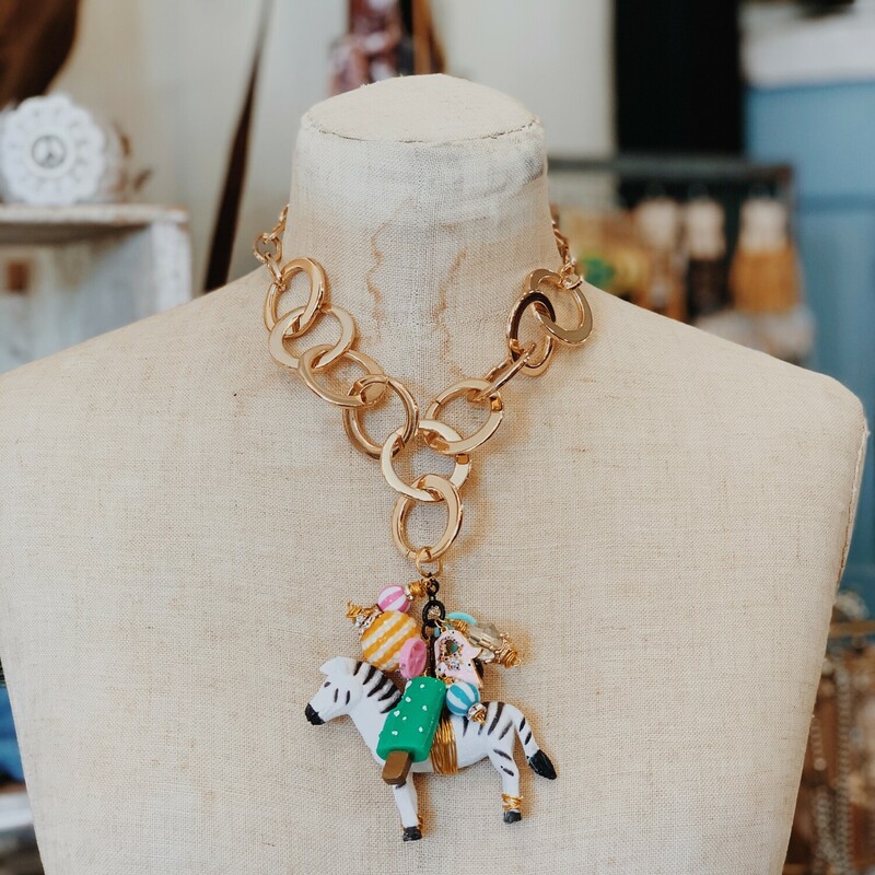 Handmade chunky gold necklace decorated with a zebra and brightly colored found objects