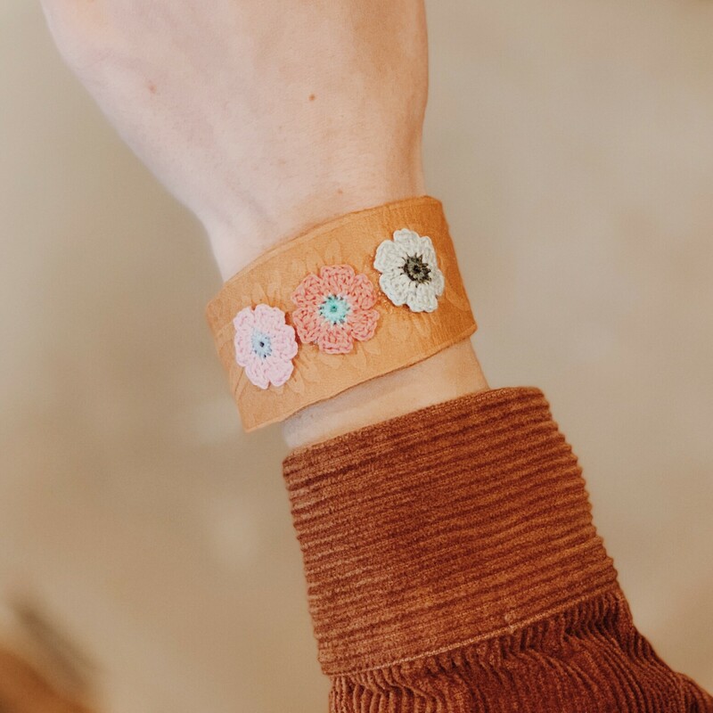 This adorable leather cuff by Kelli Hawk Designs is adjustable for a wide variety of sizes! On the front you will find three beautifully crocheted daisies!
