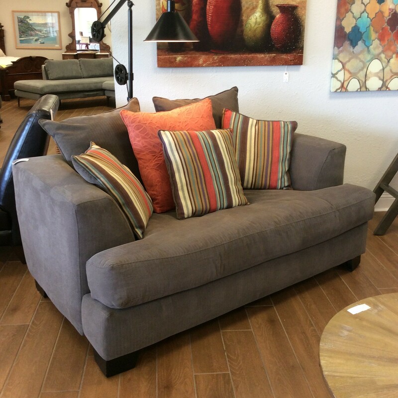 This loveseat is upholstered in gray and comes with accessory pillows.