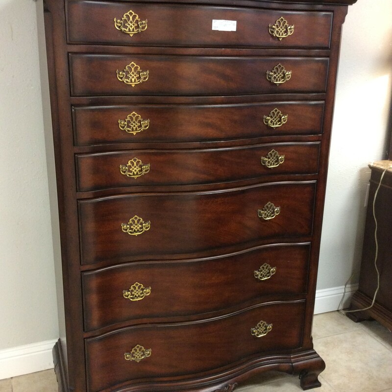 This highboy is from Universal Furniture. It features a dark wood finish an includes 7 drawers and brass hardware.