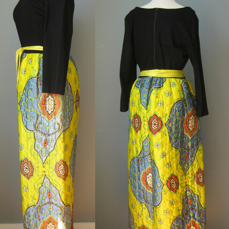 This 1970s maxi dress was made by Montgomery Ward (aka Sears)  It's a budget friendly version of a style that was so popular with hostesses in the 1970s.  It lent a kind of boho glam to suburban patio entertaining.  This one is made of synthetic materials.  the top is a black kint, not stretchy, a little rough to the touch,  it has an open round neckline.  The skirt is made of a thickish quilted yellow and blue large scale paisley satin.

Center back metal zipper
Should fit a modern size medium, please use measurements provided to be sure.
Flat measurements:
Shoulder to shoulder 17
Armpit to Armpit: 19.25
Waist: 16.75
Hip: up to 23
Length :  55
underarm sleeve seam: 14
Excellent condition, with a little bit of fading along the edge of the sleeves from light exposure.
Thank you for looking!
#39400
