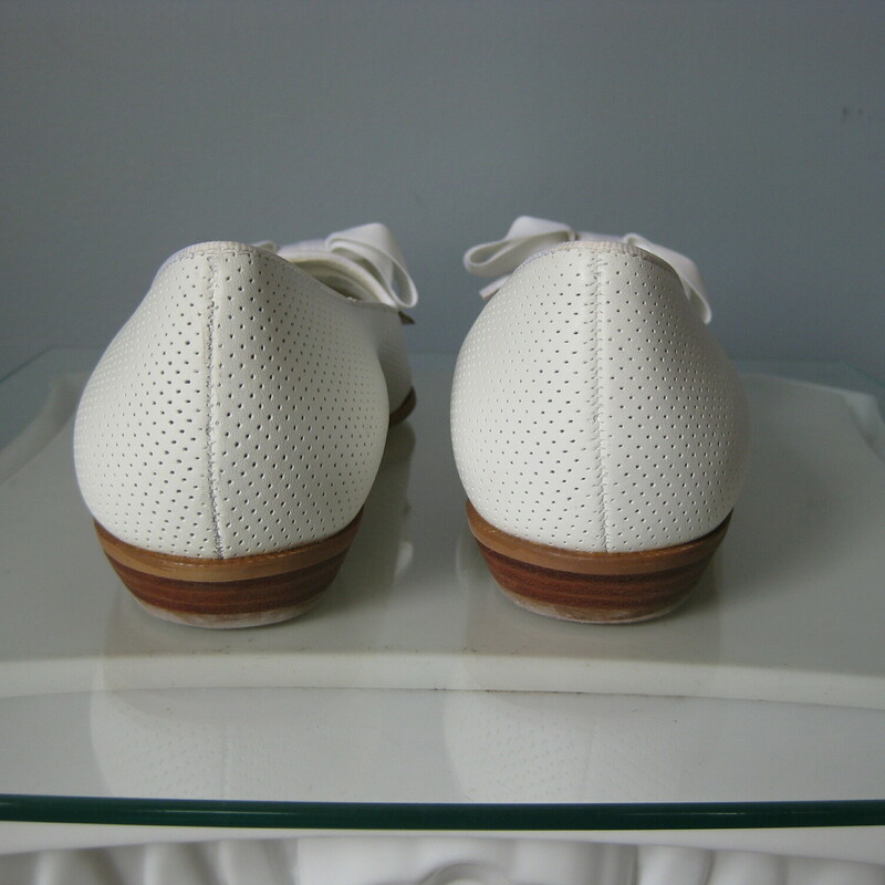 Super cute white leather flats from Nine West with big white gros grain bows.<br />
These are from the 90s or early 2000s, but they've never been worn.<br />
Size 8<br />
<br />
There is one tiny brown spot on one of the bows.  I think it may be a spec of glue from the mfg process that has darkened with time.<br />
<br />
US Size 8<br />
thanks for looking!<br />
#46202