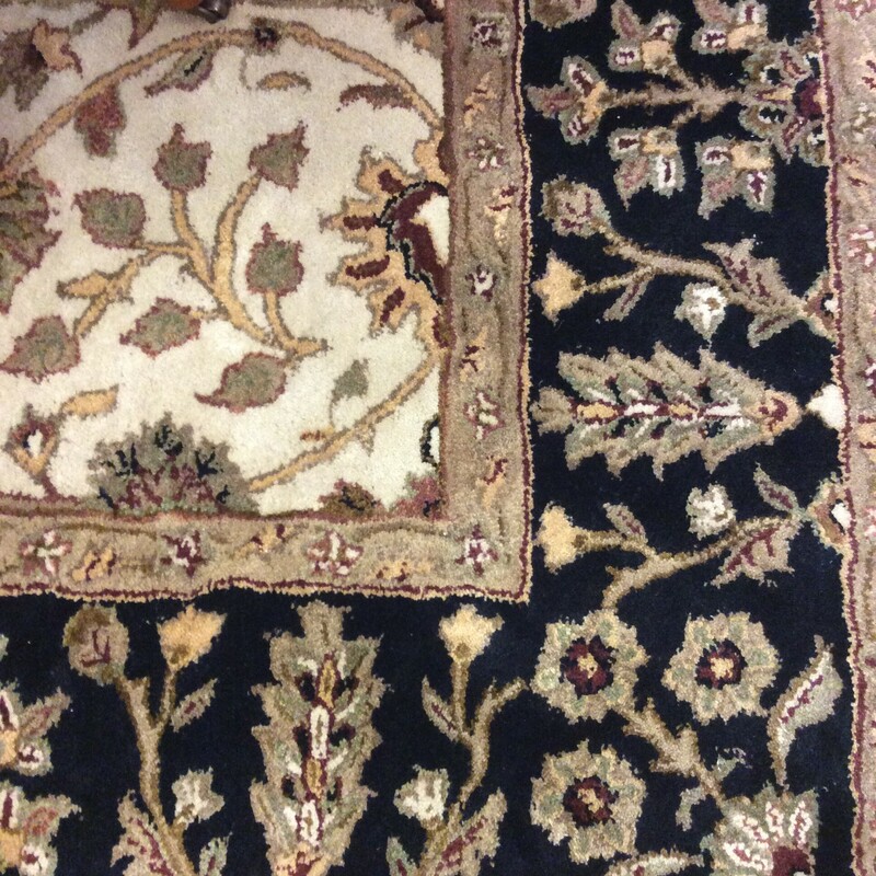 This area rug is by Feizy. It features a leafy/floral pattern in black, brown and cream.