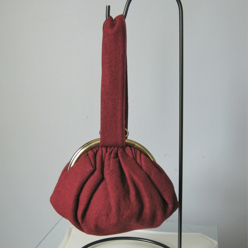 Roudish burgundy vintage wrislet or reticule in wool felt.  Very feminine.  Gold half circle frame with pretty kiss lock clasp.
No Tags
Fabric lining

Excellent condition.

Width: 9
Height: 5.5
Depth: 35
Handle drop: 8 1/2

Thanks for looking!
#42117